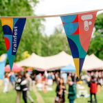 A stretch tent marquee out of focus in the background, with pendant flags in the foreground. Corporate party themes